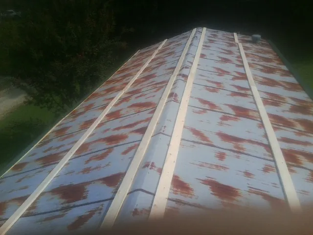 Rusted metal roof panels with new wood purlins before replacement — Storm Damage Roof Repair in Aquebogue by Roofing Brothers